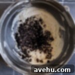 Crushed oreos in a bowl of frosting.