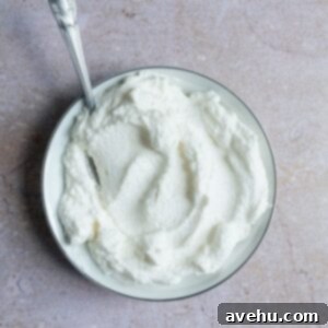 Whipped cream in a bowl on a pink surface.
