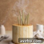 Decadent Triple Caramel Cake 6 A caramel cake with blown out candles on a peach colored surface.