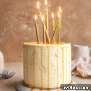 Decadent Triple Caramel Cake 2 A three-layer caramel cake, beautifully decorated with caramel drizzle and celebratory candles, presented on an elegant, overturned plate.