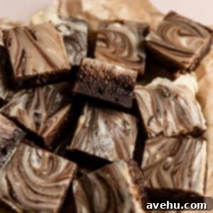 Simple Fudgy Cream Cheese Swirl Brownies 2 Cream cheese brownies served on brown parchment paper.