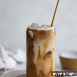 Whip Up Iced Coffee in 60 Seconds 2 A cup of iced coffee with creamer on a brown plate.