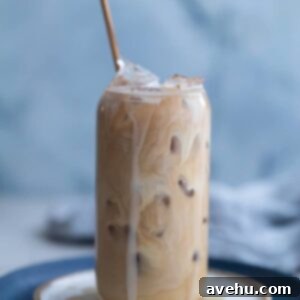 Vanilla iced coffee in a glass cup on a white plate, ready to be served.