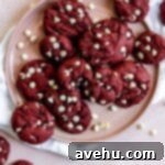 Effortless Red Velvet Cake Mix Cookies 7 Red velvet cookies with white chocolate chips on a pink plate.