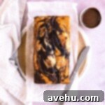 A marble loaf cake layered on parchment paper on a plate.