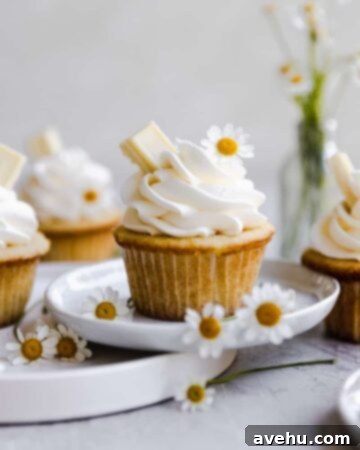 Sweet Secrets to Adorable Cupcakes 5 A vanilla cupcake decorated with white flowers.