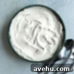 Achieve Perfect Frosting Consistency Instantly 6 Thicken cream cheese frosting in a bowl on a blue surface.