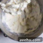 Achieve Perfect Frosting Consistency Instantly 5 A thick frosting in a bowl with the paddle attachment pulled out.