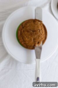 From Sunken to Superb: 5 Reasons Your Cake Sinks and 3 Simple Fixes 3 A serrated knife cutting off the top of a cake to level it off.