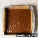 Decadent Banana Fudge Brownies 6 Banana brownie batter in a parchment lined brownie tin.