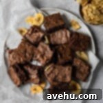 Decadent Banana Fudge Brownies 7 Banana brownie squares arranged on a plate next to banana chips.