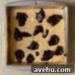 Ultimate Banana Bread Brownies 8 Brownie batter dolloped on top of banana bread batter in a pan.