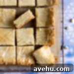 Irresistible White Chocolate Blondies 7 A batch of cut white chocolate brownies on a wire rack.