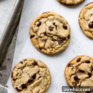 Perfectly round chocolate chip cookies next to each other on a tray.