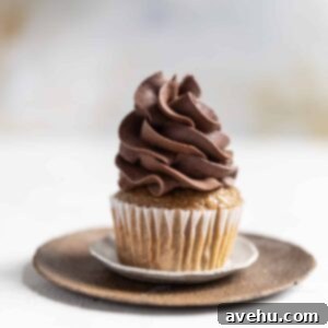 A cupcake topped with whipped chocolate ganache frosting.