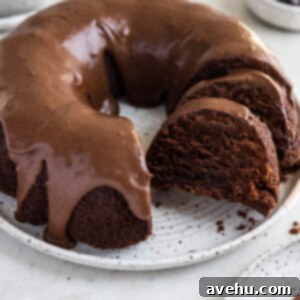 Handcrafted Fudgy Chocolate Brownie Masterpiece 2 A beautifully baked Fudgy Chocolate Brownie Cake, sliced and presented on a white plate, showcasing its rich, dense texture and topped with a creamy frosting.