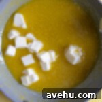 Velvet Zest Lemon Curd Cake 8 Cubed butter in a pan of lemon curd.