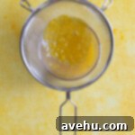 Velvet Zest Lemon Curd Cake 9 Strained lemon curd on top of a bowl.