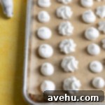 Velvet Zest Lemon Curd Cake 12 Mini meringues on a sheet tray.