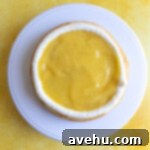 Velvet Zest Lemon Curd Cake 13 A cake filled with lemon curd and a buttercream border.