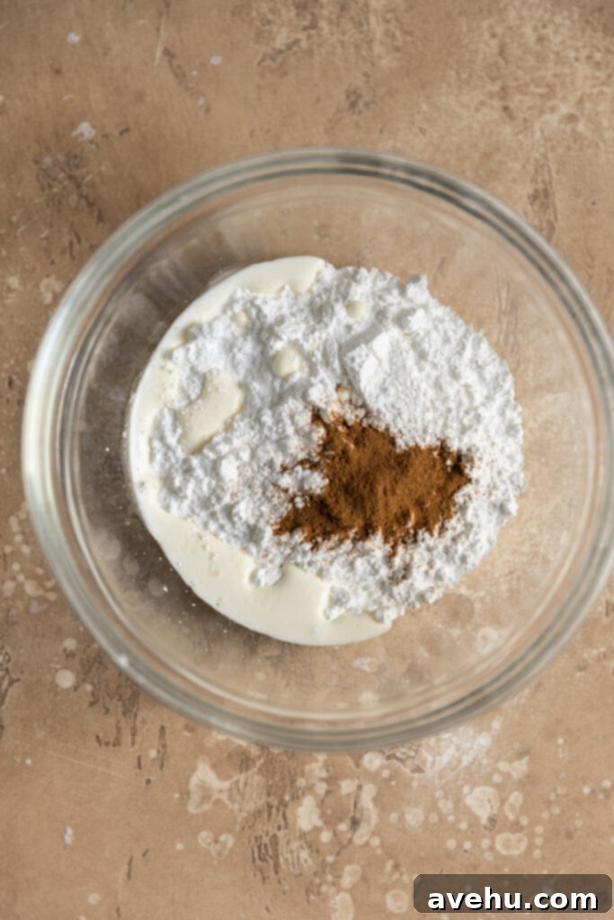 Whip Up 60-Second Cinnamon Cake Drizzle 2 A glass bowl with powdered sugar, milk, and cinnamon inside, ready to be mixed.