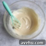 Instant Cream Cheese Glaze Perfection 4 White cream cheese glaze in a glass bowl.