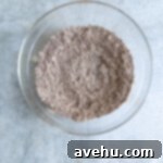 Effortless Chocolate Glaze 3 Dry ingredients for a chocolate glaze in a glass bowl.