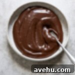 Effortless Chocolate Glaze 4 Chocolate glaze in a shallow bowl with a spoon.