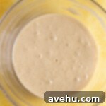 Artisan Pineapple Upside Down Minis 8 Wet ingredients in a glass bowl on a yellow surface.