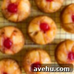 Artisan Pineapple Upside Down Minis 11 Pineapple upside down cupcakes on a wire rack.