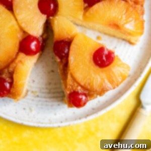 Baked From Scratch Pineapple Upside Down Cake 2 A slice of upside down pineapple cake cut on a white plate.