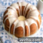 An orange bundt cake frosted with orange glaze, ready for serving.