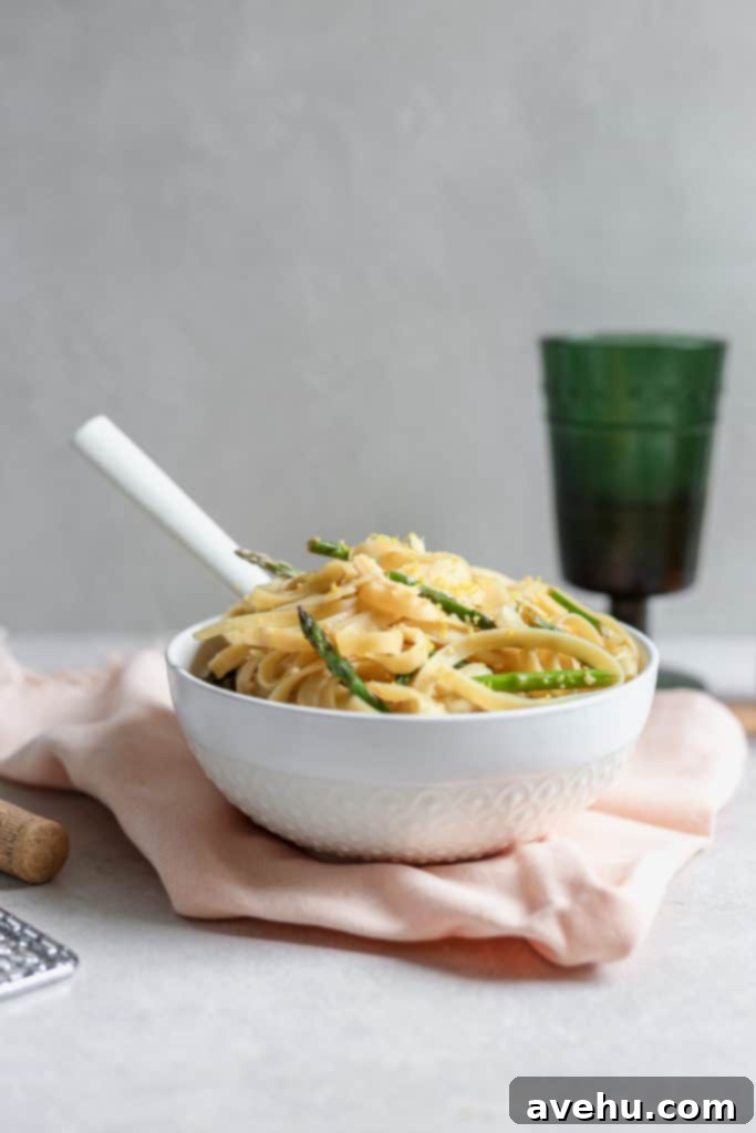 Asparagus and Lemon Fettuccine with Shaved Parmesan 3 Fettuccine pasta dish with asparagus and lemon served in a white bowl over a pink napkin