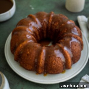 A pumpkin bundt cake with caramel glaze on a white plate.