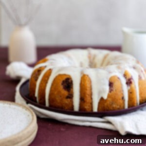 A white chocolate raspberry cake with a generous drizzle of homemade white chocolate glaze, ready to serve.