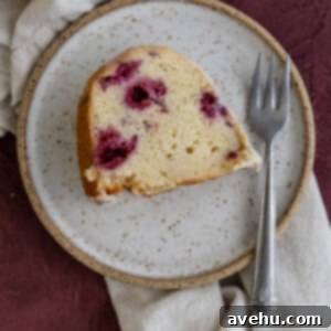 A slice of cake on a textured plate with a fork.