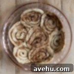 Effortless Cinnamon Roll Apple Pie 3 Cinnamon rolls flattened to form a crust in a pie plate.