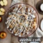 Effortless Cinnamon Roll Apple Pie 7 Cinnamon Roll Apple Pie in a pie dish on a wooden surface.