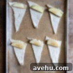 Buttery Flaky Apple Dumplings 4 An unwrapped crescent roll with a slice of apple positioned at its widest part, ready for rolling.