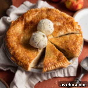 Crisp Puff Pastry Apple Dream 2 A slice of puff pastry apple pie served warm with a scoop of melting vanilla ice cream on top, ready to eat.