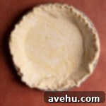 Crisp Puff Pastry Apple Dream 3 Puff pastry sheet carefully lining a pie plate, ready for pre-baking, showing the edges folded over.