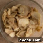 Effortless Graham Cracker Apple Pie 6 Thinly sliced spiced apples in a mixing bowl.