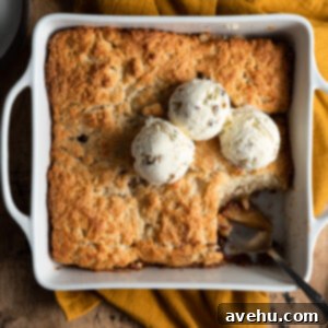 Homemade Apple Cobbler 2 Apple cobbler with ice cream on top and a sliced scooped out with a spoon.