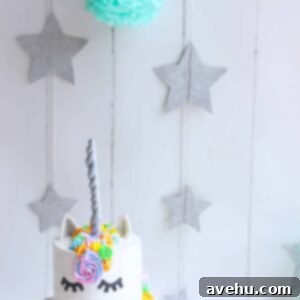 My Blog Debut: A Unicorn Cake Wonderland 2 A white cake decorated to look like a unicorn on a white backdrop with sparkly stars hanging in the back