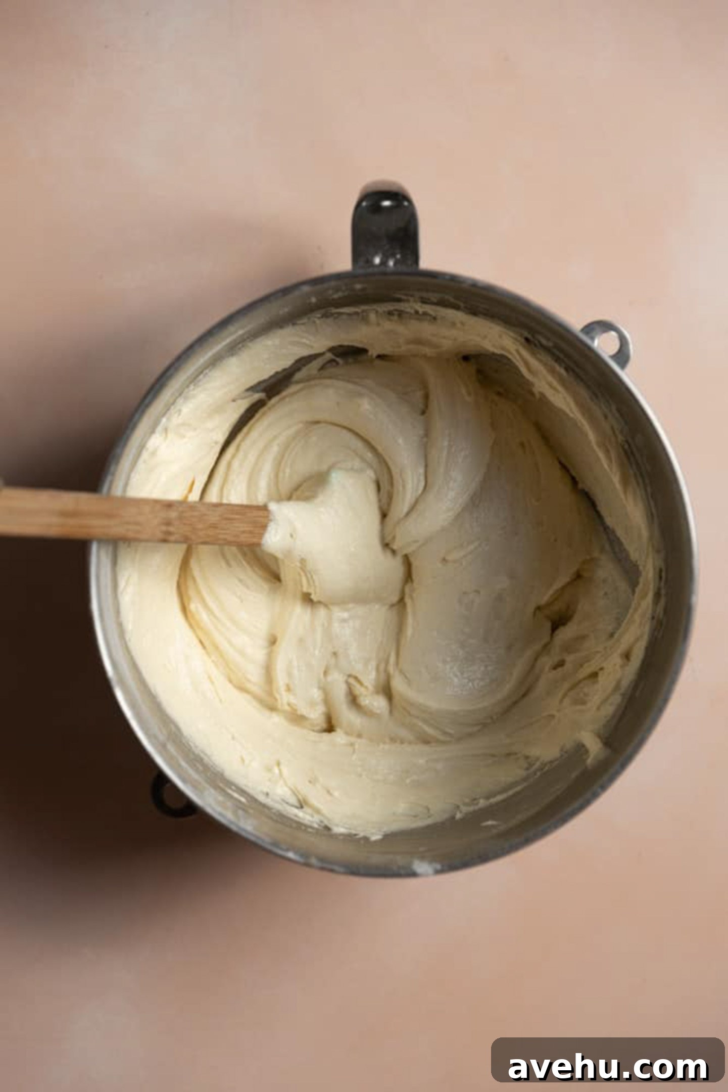 Yellow cake batter in a mixing bowl with a spatula in it.