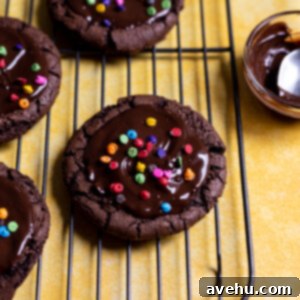 Quick Fudgy Cosmic Brownie Cookies 2 A cosmic brownie cookie on a wire rack with rainbow chips on top.