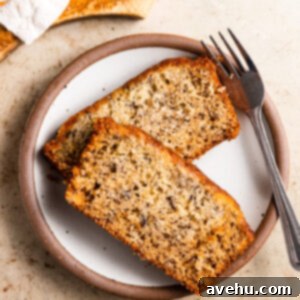 Velvety Oil-Baked Banana Bread 2 Two slices of banana bread on a plate next to a fork.