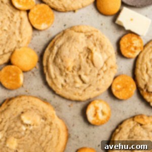 Effortless Banana Pudding Cookies 2 Banana pudding cookies next to wafer cookies on a beige surface.