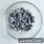 Bright & Zesty Lemon Blueberry Cupcakes 16 Fresh blueberries coated in flour in a glass bowl.