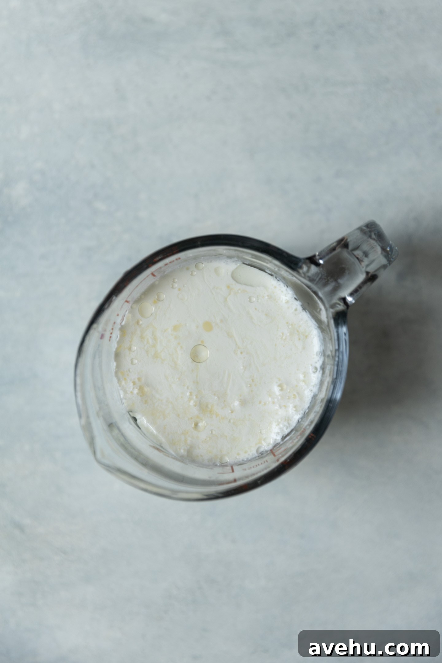 Bright & Zesty Lemon Blueberry Cupcakes 3 A measuring cup filled with buttermilk, showing its characteristic slightly curdled texture, ready for use in baking.